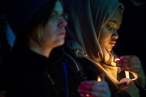 FILE - In this Feb. 11, 2015 file photo, University of Michigan-Flint freshman Lina Eltahir, 17, right, stands with others at a candlelight vigil at the school in Flint, Mich., in memory of three people who were killed near UNC-Chapel Hill, N.C. Vigils across the county popped up in the wake of this tragedy. "I don&#8217;t know that I've ever seen this many vigils come together this quickly and be so well attended," said Zahra Billoo, executive director of the Council on American-Islamic Relations' San Francisco Bay Area chapter. "It gives me relief that the three young people in Chapel Hill inspired so much mobilization and love and activism." (AP Photo/The Flint Journal, Jake May, File) LOCAL TELEVISION OUT; LOCAL INTERNET OUT