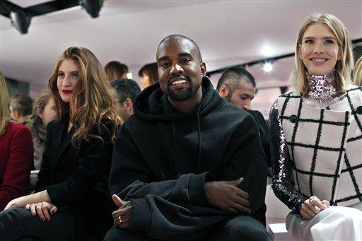 Kanye West, centre and Elena Perminova, right, wife of Russian billionaire Alexander Lebedev attend Christian Dior's fall-winter 2015-2016 fashion collection, as part of Paris Fashion Week, presented in Paris, France, Friday, March 6, 2015. (AP Photo/Thibault Camus)