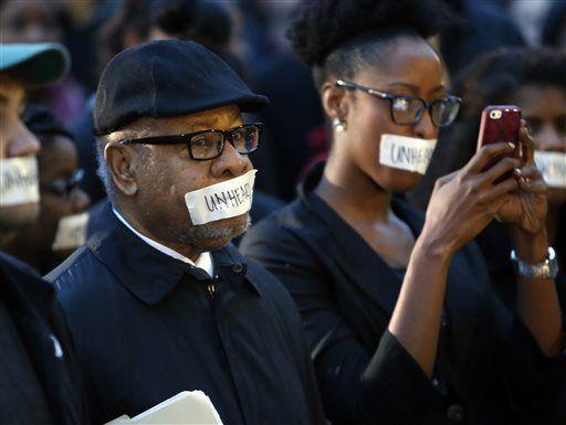 George Henderson, left, professor emeritus, joins students at the University of Oklahoma to protest a fraternity's racist comments on March 9, 2015 in Norman, Okla. University President David Boren lambasted members of Sigma Alpha Epsilon fraternity on Monday who participated in a racist chant caught on video, calling them disgraceful and their behavior reprehensible, and ordered that their house be vacated by midnight Tuesday. (AP Photo/The Oklahoman, Steve Sisney)