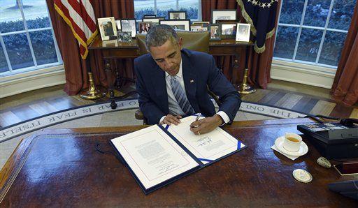 President Barack Obama signs H.R. 240, the Department of Homeland Security Appropriations Act of 2015, Wednesday, March 4, 2015, in the Oval Office of the White House in Washington. The president signed a law funding the Homeland Security Department through the end of the budget year. The president signed the bill Wednesday afternoon in the Oval Office with a small group of photographers present. The White House wouldn't permit reporters to attend. (AP Photo/Susan Walsh)