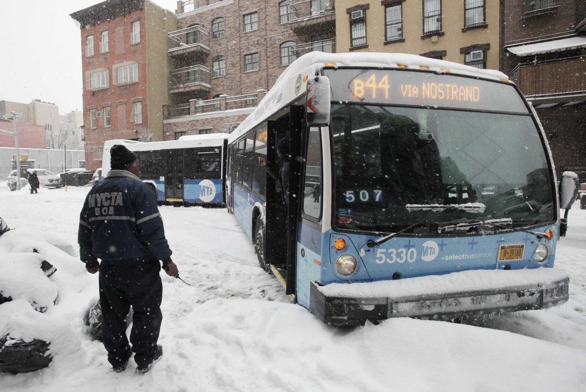 An employee with the New York City Transit Authority looks at an articulated city bus that had blocked the road during a snowstorm, Thursday, March 5, 2015 in the Williamsburg neighborhood of the Brooklyn borough of New York. The National Weather Service has issued a winter storm warning for heavy snow for New York City and Long Island Weather officials predict snow accumulations of between 4 and 7 inches. (AP Photo/Mark Lennihan)