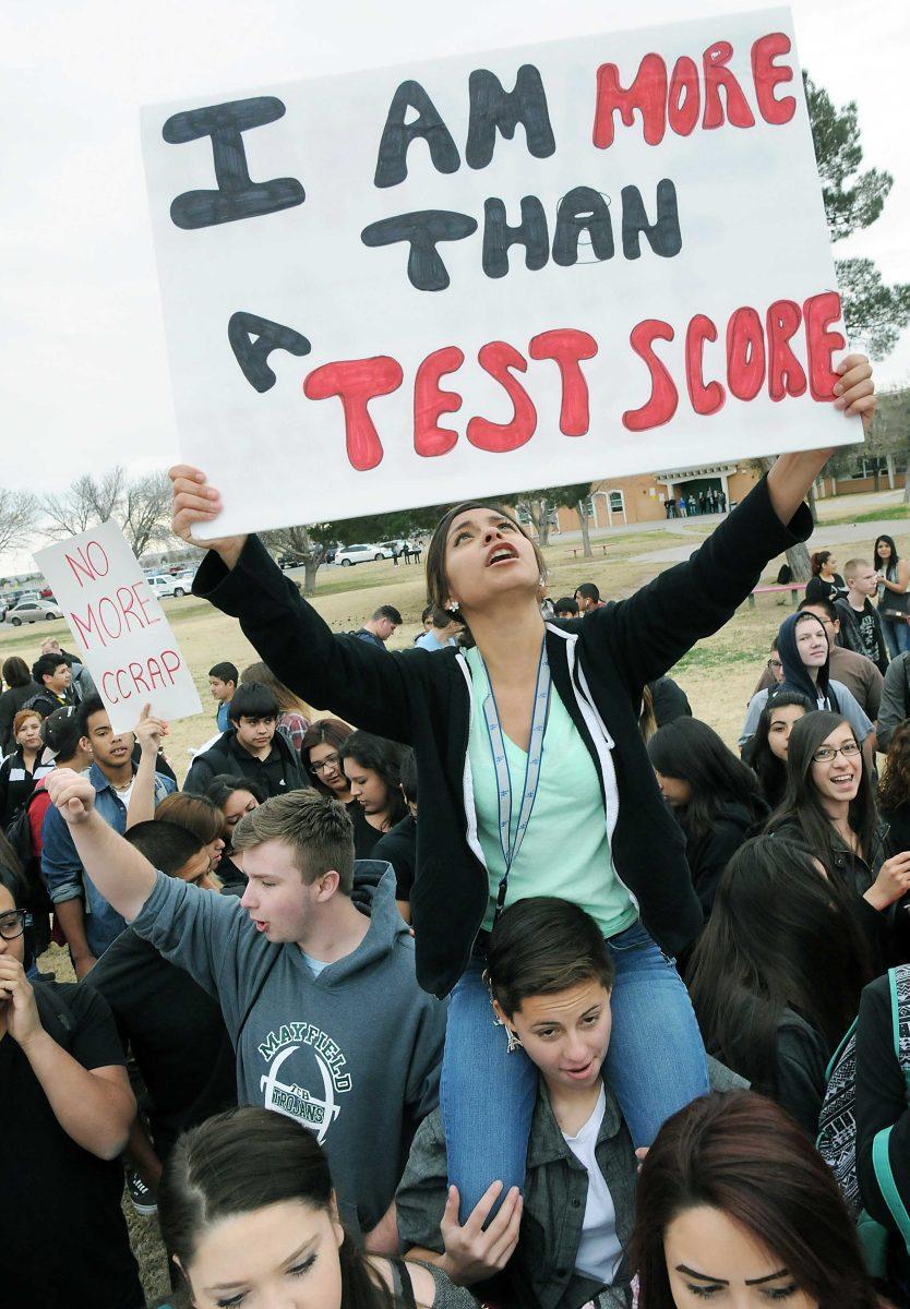 Mayfield High School junior Laura Cruz, 18, looks up at the sign she is holding on Monday, March, 2, 2015, during a student-organized walkout to protest the PARCC exams in Las Cruces, N.M. Students frustrated over the new standardized test planned school walkouts across New Mexico to protest the requirement. (AP Photo/Las Cruces Sun-News, Robin Zielinski)