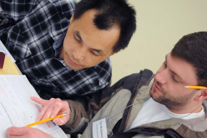 LSU 3L senior Law Student Tim McGibboney helps out LSU Natural Resources Ph. D student Jinlong Zhang on Tuesday, Mar. 10, 2015 with his taxes at the Law Center.