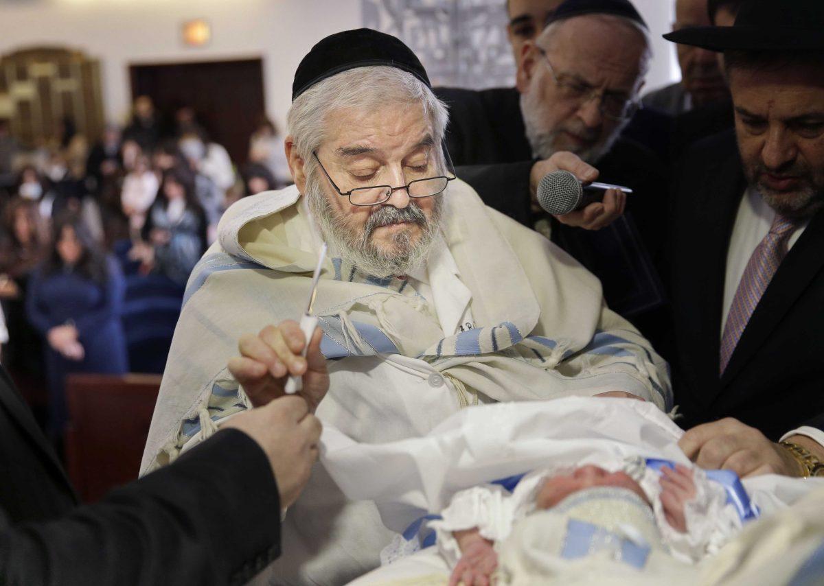 In this Feb. 11, 2015 photo, Abraham Romi Cohn is handed a scalpel during the bris, or ritual circumcision, of Yosef Sananas in New York. Mayor Bill de Blasio&#8217;s administration is negotiating a medical protocol that would allow for religious freedom as it navigates health officials' concern over the practice of oral suction during ultra-Orthodox circumcision ceremonies, in which a rabbi sucks blood from a wound on the penis. (AP Photo/Seth Wenig)