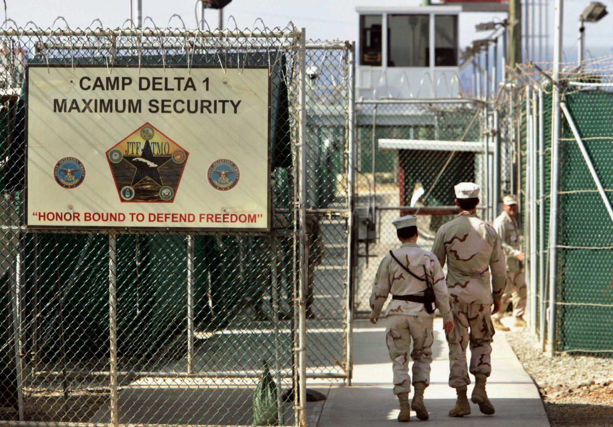 FILE - In this June 27, 2006 file photo, reviewed by a U.S. Department of Defense official, U.S. military guards walk within Camp Delta military-run prison, at the Guantanamo Bay U.S. Naval Base, Cuba. The Supreme Court is allowing the Obama administration to keep secret photographs and videotapes of a Guantanamo Bay detainee identified as the would-be 20th hijacker in the Sept. 11 terror attacks. The justices on Monday turned away an appeal from a human rights group that argued the release of videotapes and photographs of the interrogation and confinement of Mohammed al-Qahtani would serve the public interest. The Center for Constitutional Rights has accused the FBI and military personnel of subjecting al-Qahtani to isolation and aggressive interrogation techniques in 2002. (AP Photo/Brennan Linsley, File)