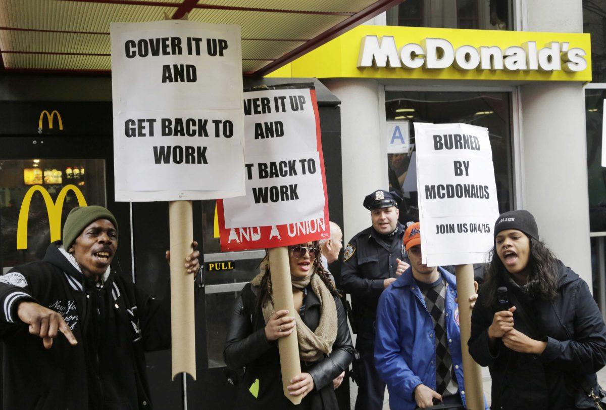 Dozens of fast food workers and their supporters protest workplace conditions in front of a McDonald's restaurant, Tuesday, March 17, 2015 in New York. Labor organizers say McDonald's workers in 19 cities have filed complaints over burns from grease, a lack of protective equipment and other workplace hazards. It's the latest move in a campaign to win pay of $15 an hour and unionization for fast-food workers by publicly pressuring McDonald's. The company says franchisees are committed to providing safe working conditions, but it will review the allegations detailed in complaints filed with U.S. Occupational Safety and Health Administration. (AP Photo/Mark Lennihan)