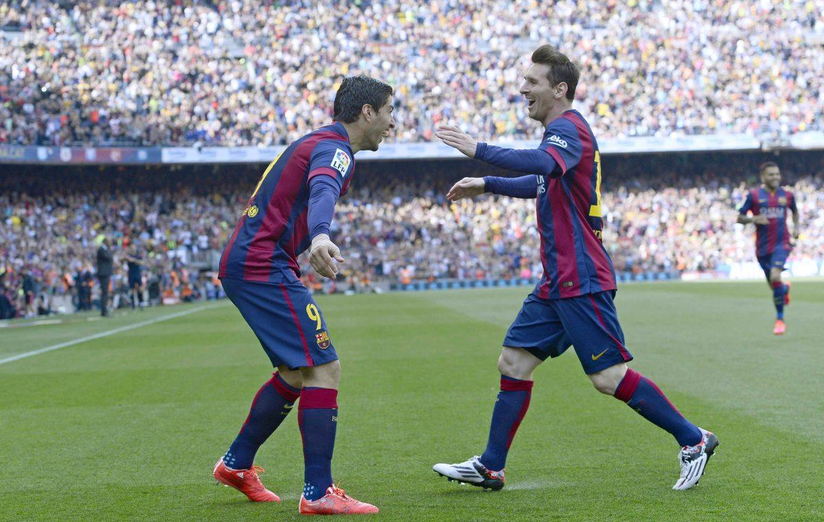 FC Barcelona's Luis Suarez, left, celebrates after scoring against Valencia with his teammate Lionel Messi during a Spanish La Liga soccer match at the Camp Nou stadium in Barcelona, Spain, Saturday, April 18, 2015. (AP Photo/Manu Fernandez)