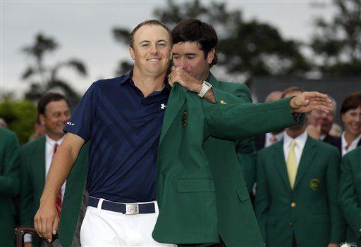 Bubba Watson helps Jordan Spieth put on his green jacket after winning the Masters golf tournament Sunday, April 12, 2015, in Augusta, Ga. (AP Photo/David J. Phillip)