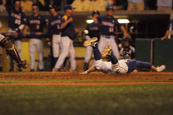 LSU junior outfielder, Andrew Stevenson (6), slides in to home as the ball passes over him during LSU's 9-6 win at game two of the SEC Championships against Texas A&amp;M on Friday, April 24, 2015 in Alex Box Stadium.