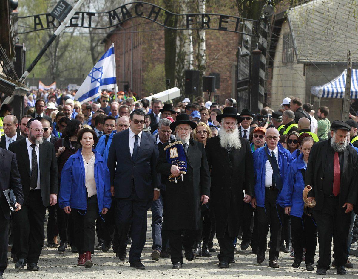 Thousands of participants from across the world pass through the notorious gate with the letters &#8220;Arbeit Macht Frei&#8221; (Work Sets You Free) during the annual March of the Living at the start in the former Auschwitz Nazi death camp memorial to begin their silent walk to the Birkenau part of the camp, to honor more than 1 million people, mostly Jews, killed at the camp from 1940-45, in Oswiecim, Poland, Thursday, April 16, 2015. (AP Photo/Czarek Sokolowski)