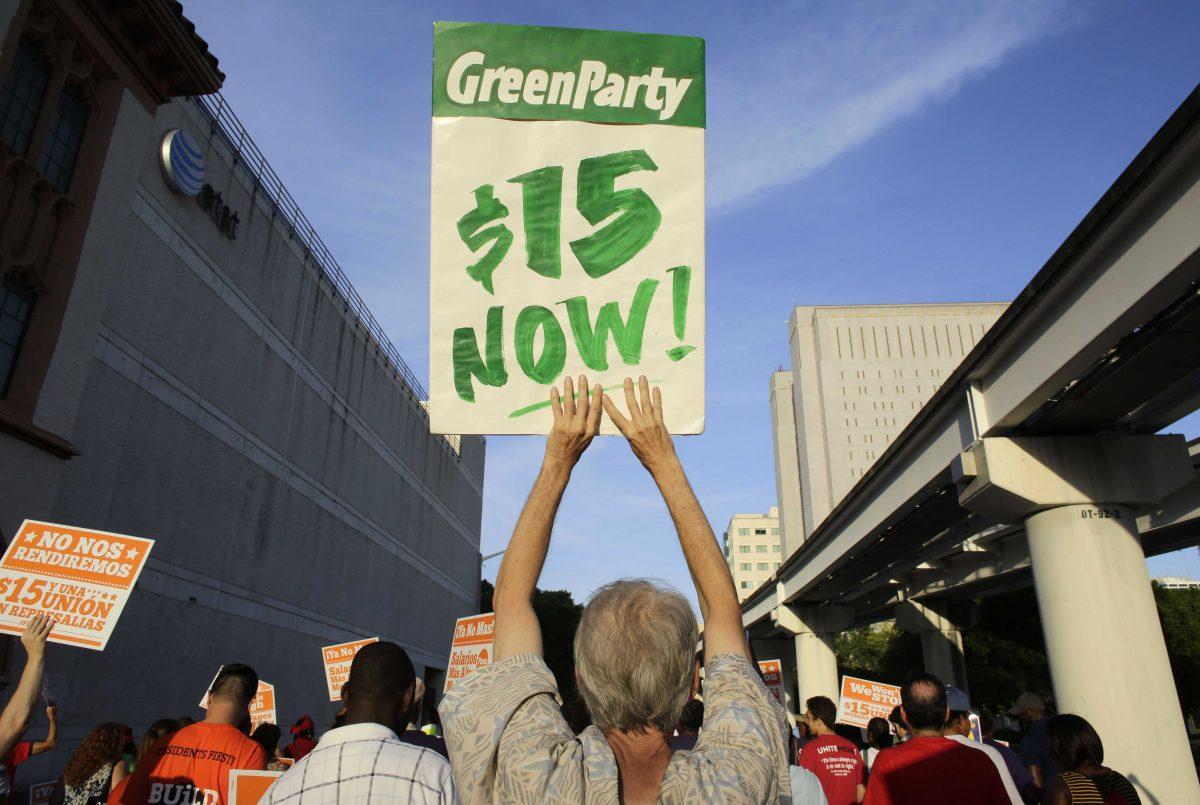 Protestors march in support of raising the minimum wage to $15 an hour as part of an expanding national movement known as Fight for 15, Wednesday, April 15, 2015, in Miami. The event was part of a national protest day to coincide with the April 15 deadline for filing income taxes. (AP Photo/Lynne Sladky)