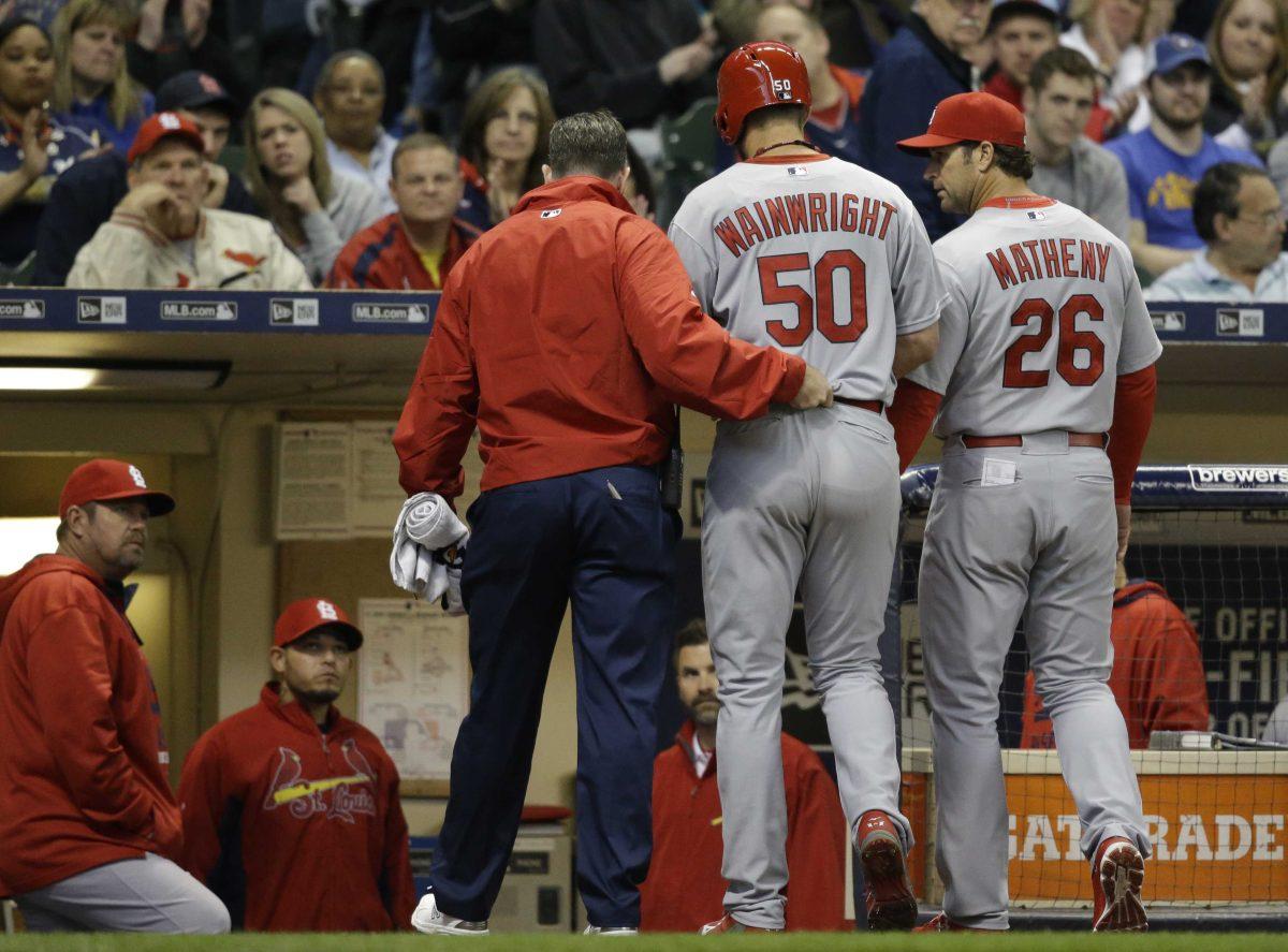 St. Louis Cardinals starting pitcher Adam Wainwright (50) is helped off the field after getting injured while batting during the fourth inning of a baseball game against the Milwaukee Brewers Saturday, April 25, 2015, in Milwaukee. (AP Photo/Jeffrey Phelps)