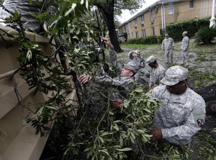 Members of the Louisiana National Guard clean up fallen limbs along St. Charles Ave. in New Orleans,Thursday, Aug. 30, 2012. Isaac's maximum sustained winds had decreased to 45 mph and the National Hurricane Center said it was expected to become a tropical depression by Thursday night. The storm's center was on track to cross Arkansas on Friday and southern Missouri on Friday night, spreading rain as it goes. (AP Photo/David J. Phillip)