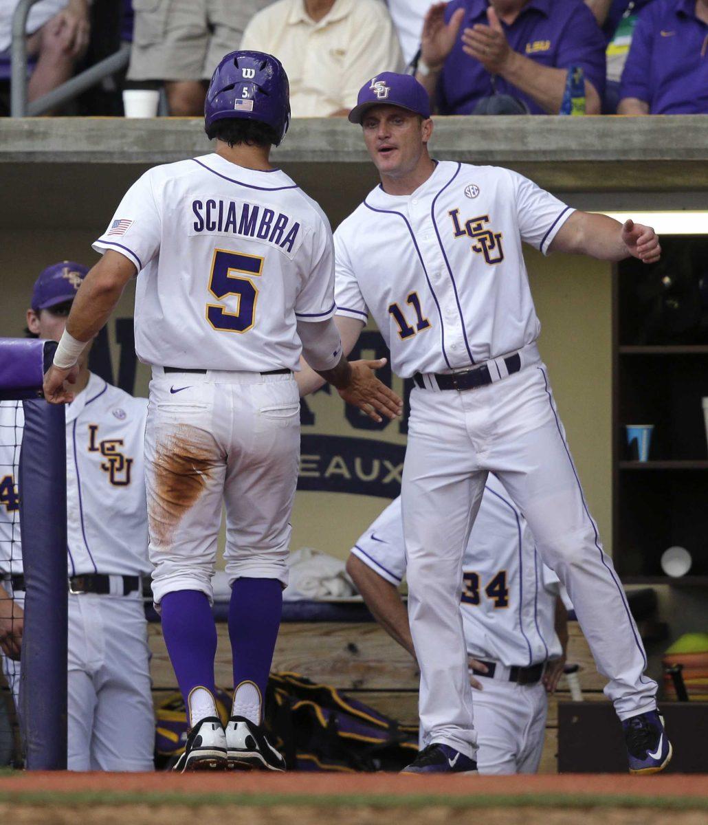 LSU outfielder Chris Sciambra (5) is greeted by hitting coach Andy Cannizaro (11) after being walked home by Lehigh pitcher Kevin Boswick in the sixth inning of a game at the Baton Rouge Regional of the NCAA college baseball tournament in Baton Rouge, La., Friday, May 29, 2015. LSU won 10-3. (AP Photo/Gerald Herbert)