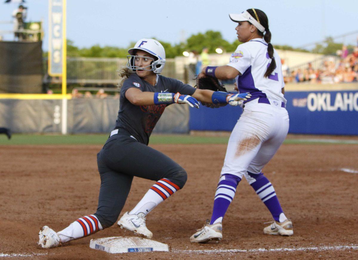 Florida's Kristi Merritt slides into third base as the LSU third baseman misses the catch in the sixth inning in the NCAA Women's College World Series softball game in Oklahoma City, Friday, May 29, 2015. (AP Photo/Alonzo Adams)