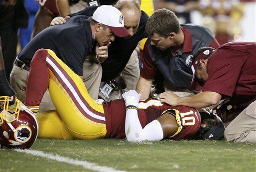 Washington Redskins quarterback Robert Griffin III (10) is examined after an injury during the first half of an NFL preseason football game against the Detroit Lions, Thursday, Aug. 20, 2015, in Landover, Md. (AP Photo/Alex Brandon)