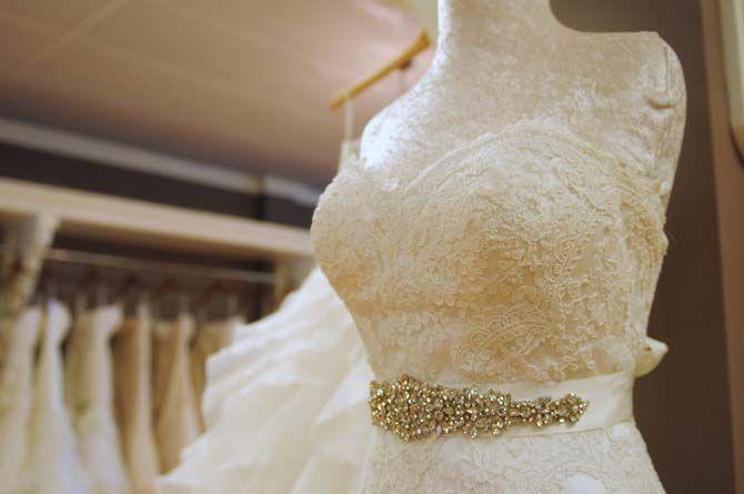 A belted and lace detailed wedding gown is displayed on a mannequin on Monday, Aug. 24, 2015, at Blush Formal and Bridal Salon.