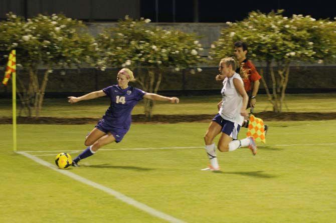 LSU senior midfielder Alex Arlitt (14) crosses the ball before falling injured Friday, August 29, 2014 during the Tigers' victory 6-2 against Northwestern St. in LSU Soccer Stadium.