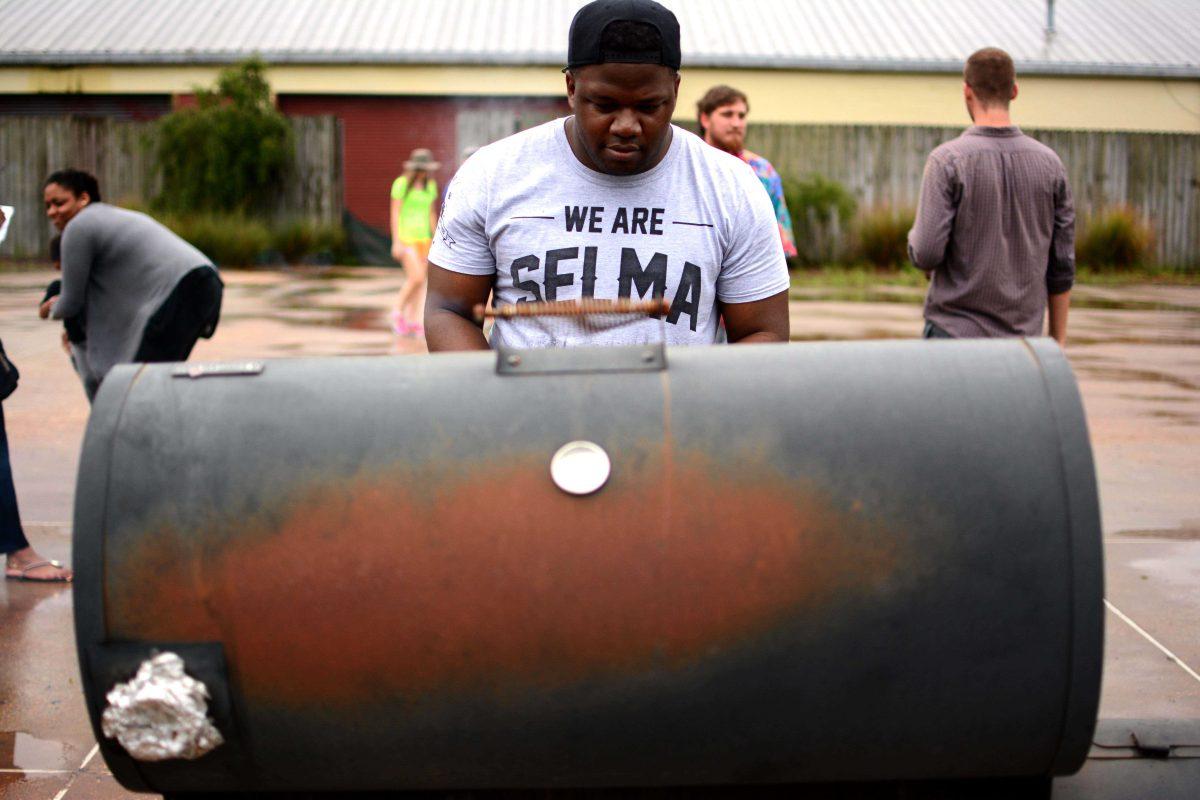 NAACP Vice President Monturios Howard grills chicken and hotdogs at an event aimed to shed light on race issues on campus.