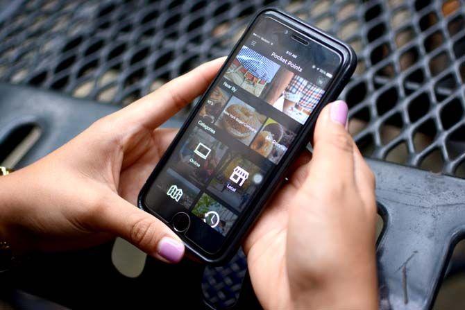 Accounting junior Xochitl Roman scrolls through the new app Pocket Points, which rewards students with discounts from local businesses for staying off their phone during class.