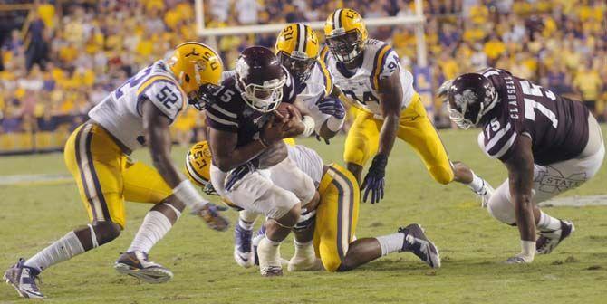 LSU junior linebacker Kwon Alexander (4) and freshman defensive end Deondre Clark (98) takle Mississippi sophmore quarterback Dak Prescott during the game Saturday where LSU lost 34-29 in Tiger Stadium.