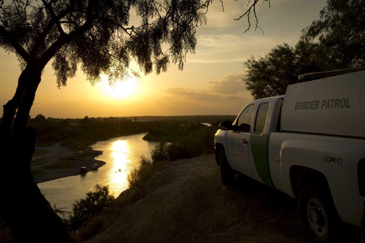 FILE - In this Wednesday, July 23, 2014 file photo, a U.S. Border Patrol agent keeps watch in Roma, Texas, across the Rio Grande River from Ciudad Miguel Aleman, Tamaulipas, Mexico. The United States and the European Union project themselves as models for the world when it comes to democracy and human rights. Yet a common issue, migration, is bitterly dividing each of them. (Jay Janner/Austin American-Statesman via AP, File)