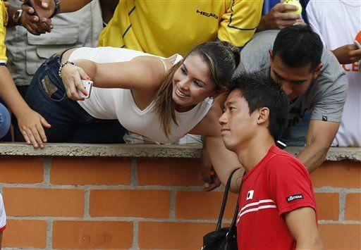 Kei Nishikori, right, of Japan poses for a selfie with a fan during the Davis Cup World Group play-offs in Pereira, Colombia, Sunday, Sept. 20, 2015. Japan won the series 3-2. (AP Photo/Fernando Vergara)