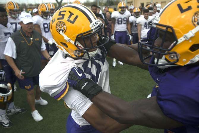 LSU sophomore wide receiver D.J. Chark (82) is held by freshmen cornerback Kevin Toliver II (2) while doing the big cat drill during practice on Thursday, March 19, 2015 in Charls McClendon Practice Facility