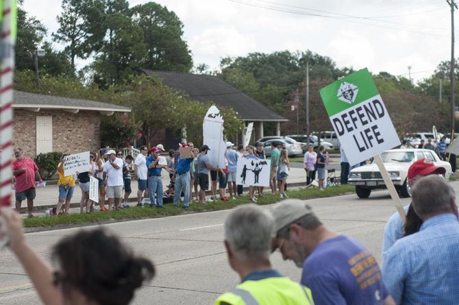 Protesters hold signs outside the planned parenthood health center on Saturday, Aug. 22, 2015 on Government Street.