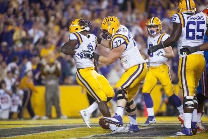 LSU sophomore running back Leonard Fournette (7) drags the University of Florida junior linebacker Daniel McMillan (13) and sophomore defensive back Nick Washington (8) across the goal line for an LSU touchdown, bringing the score to 27-14 Tigers on Saturday Oct. 17, 2015, in Tiger Stadium on LSU's campus.