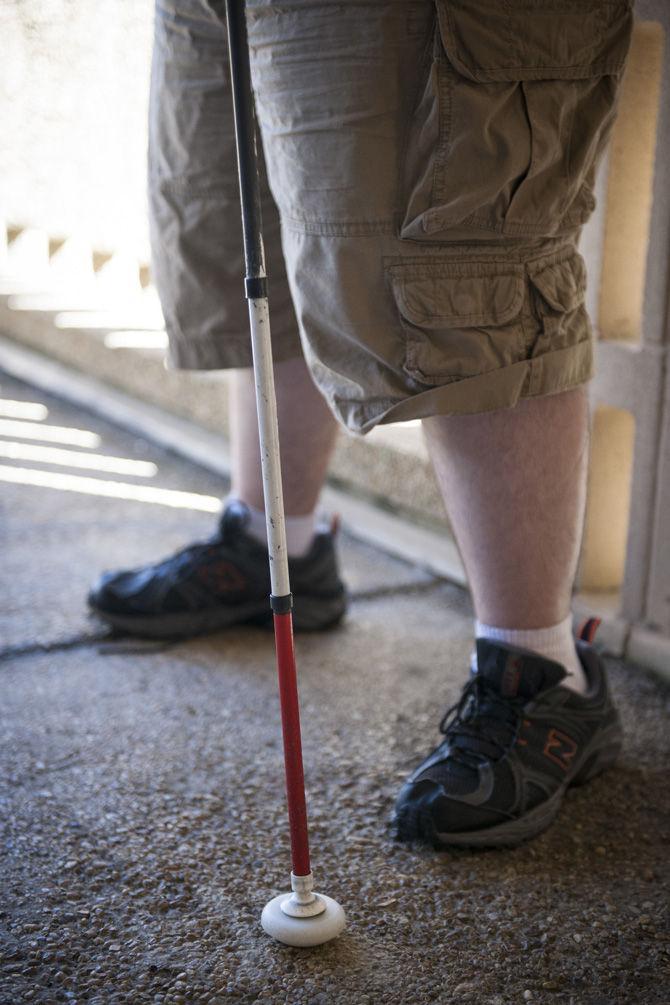 LSU physics sophomore Justin Champagne uses his walking stick as an aid for getting around on Wednesday, Oct. 15, 2015, in the Student Union.