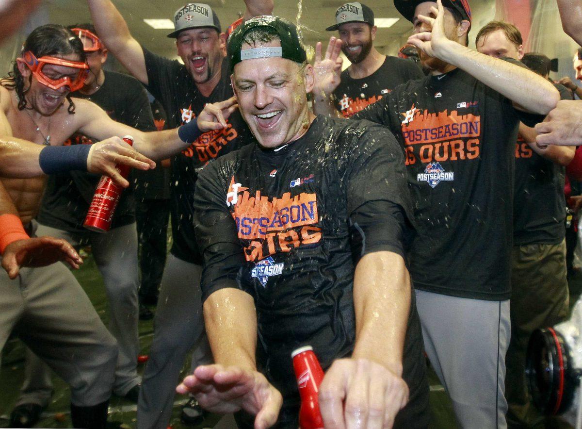 Houston Astros manager A.J. Hinch, center, celebrates with his players after clinching an AL wild card playoff berth following a 5-3 loss against the Arizona Diamondbacks during a baseball game, Sunday, Oct. 4, 2015, in Phoenix. (AP Photo/Ralph Freso)