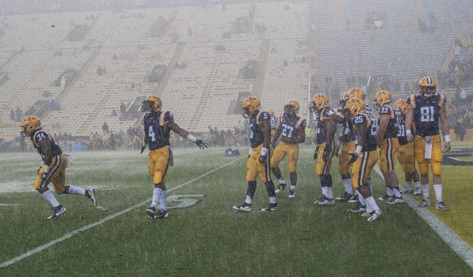 LSU football players warm up under heavy rain during the Tigers&#8217; 48- 20 victory against Western Kentucky on Saturday, Oct. 24, 2015 in Tiger Stadium.