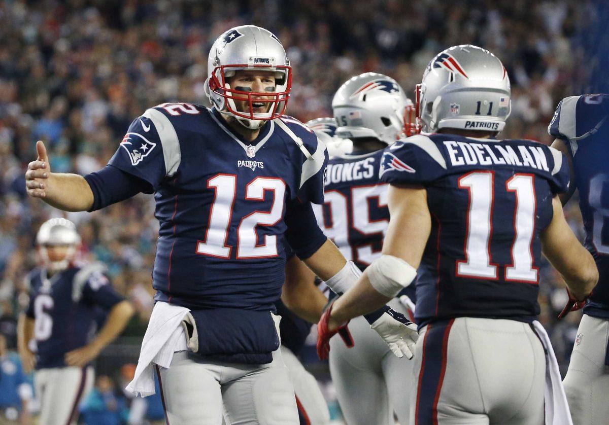 New England Patriots quarterback Tom Brady (12) celebrates his touchdown pass to wide receiver Julian Edelman (11) in the second half of an NFL football game against the Miami Dolphins, Thursday, Oct. 29, 2015, in Foxborough, Mass. (AP Photo/Michael Dwyer)