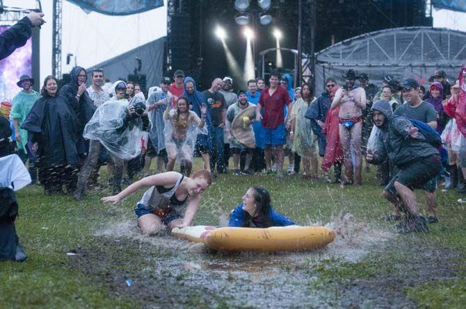 Festival goers take the rain and turn it into slipin slide during the Voodoo Music Experience on Saturday Oct. 31, 2015 in New Orleans.