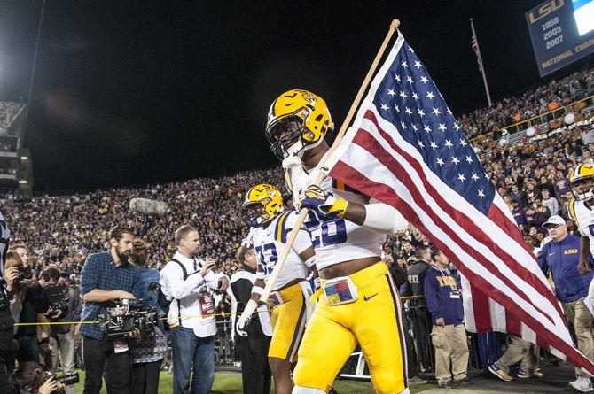 LSU senior safety Jalen Mills (28) walks out of the locker room with the American flag during before the Tigers' 31-14 defeat against The University of Arkansas on Saturday, Nov. 14, 2015 in Tiger Stadium.