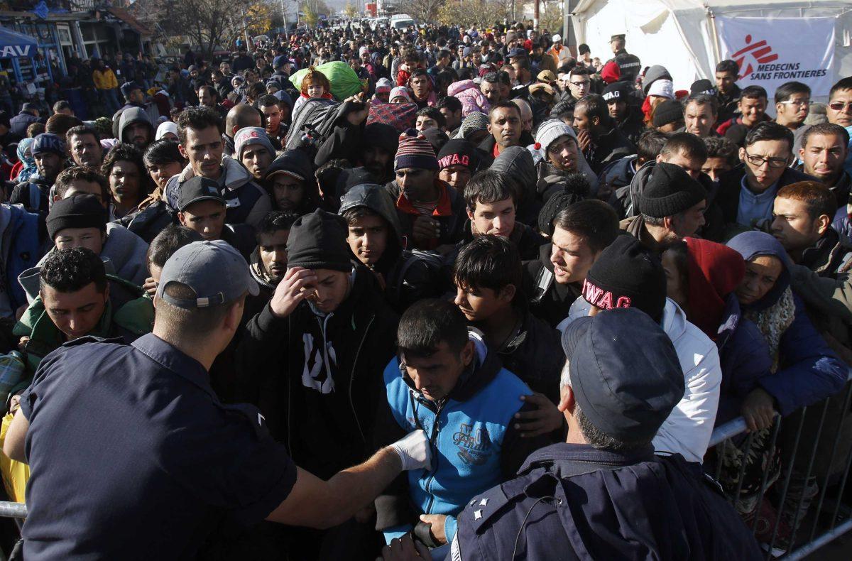 Serbian police officers trying to organise migrants queuing to get registered at a refugee center in the southern Serbian town of Presevo, Monday, Nov. 16, 2015. Refugees fleeing war by the tens of thousands fear the Paris attacks could prompt Europe to close its doors, especially after police said a Syrian passport found next to one attacker&#8217;s body suggested its owner passed through Greece into the European Union and on through Macedonia and Serbia last month. (AP Photo/Darko Vojinovic)