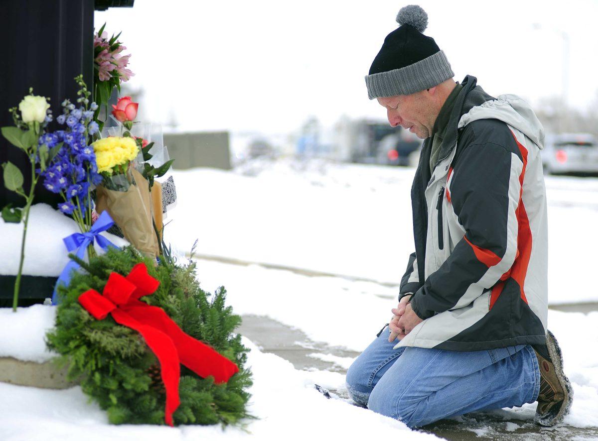 Roy Kieffer pauses after laying flowers Saturday, Nov. 28, 2015, in honor of the victims of Friday's deadly shooting at a Planned Parenthood clinic in Colorado Springs, Colo. Authorities weren't ready to discuss a possible motive Saturday after interviewing suspect Robert Lewis Dear, Colorado Springs Mayor John Suthers said. (Daniel Owen/The Gazette via AP) MAGS OUT; MANDATORY CREDIT