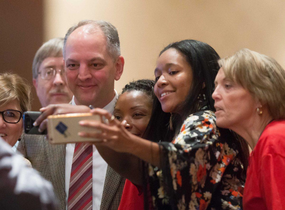 Gov.-elect John Bel Edwards takes photos with others during the Louisiana Federation of Teachers convention in Lake Charles, La., Monday, Nov. 23, 2014. In a sign of the strength of Edwards' ties to the unions, the Democrat's first speech since winning the weekend runoff election was Monday at the convention. (Rick Hickman/American Press via AP) MANDATORY CREDIT