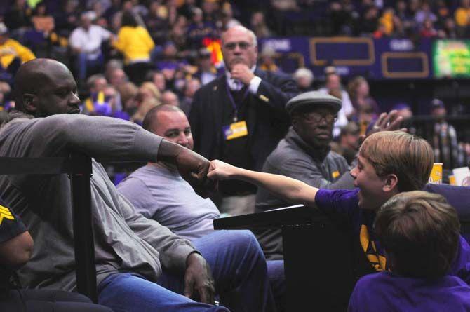 Former NBA basketball player Shaquille O'Neal exchanges a fist bump with a young LSU fan on Saturday, Jan. 10, 2015, during the Tigers' 87-84 win against Georgia in the Pete Maravich Assembly Center.