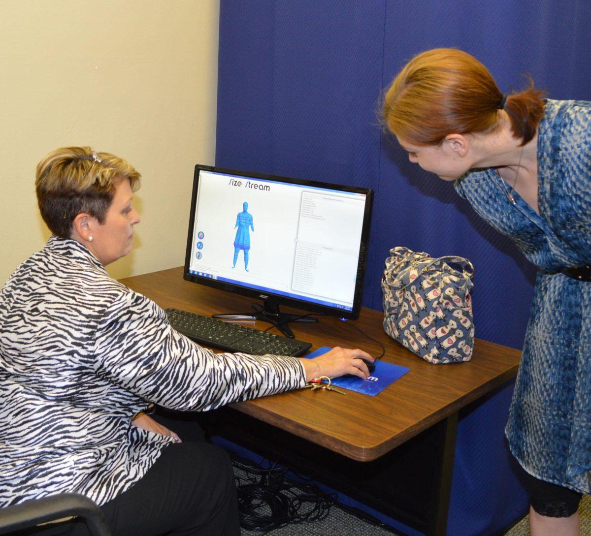 Textiles, apparel design and merchandising assistant professors Laurel Romeo and Casey Stannard work with a 3D body scanner to study how modern body shapes fit with outdated colthing sizes.