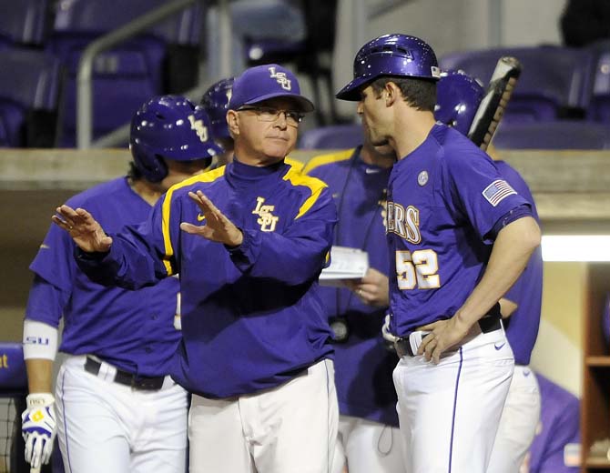 LSU head baseball coach Paul Mainieri (right) and volunteer assistant coach Will Davis speak during a pitching change Saturday, March 8, 2014 during the Tigers' 4-2 victory against Purdue at Alex Box Stadium.