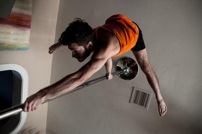 French studies, senior Joseph Albes practices a routine on the pole Monday, Jan. 18, 2016 in his apartment.