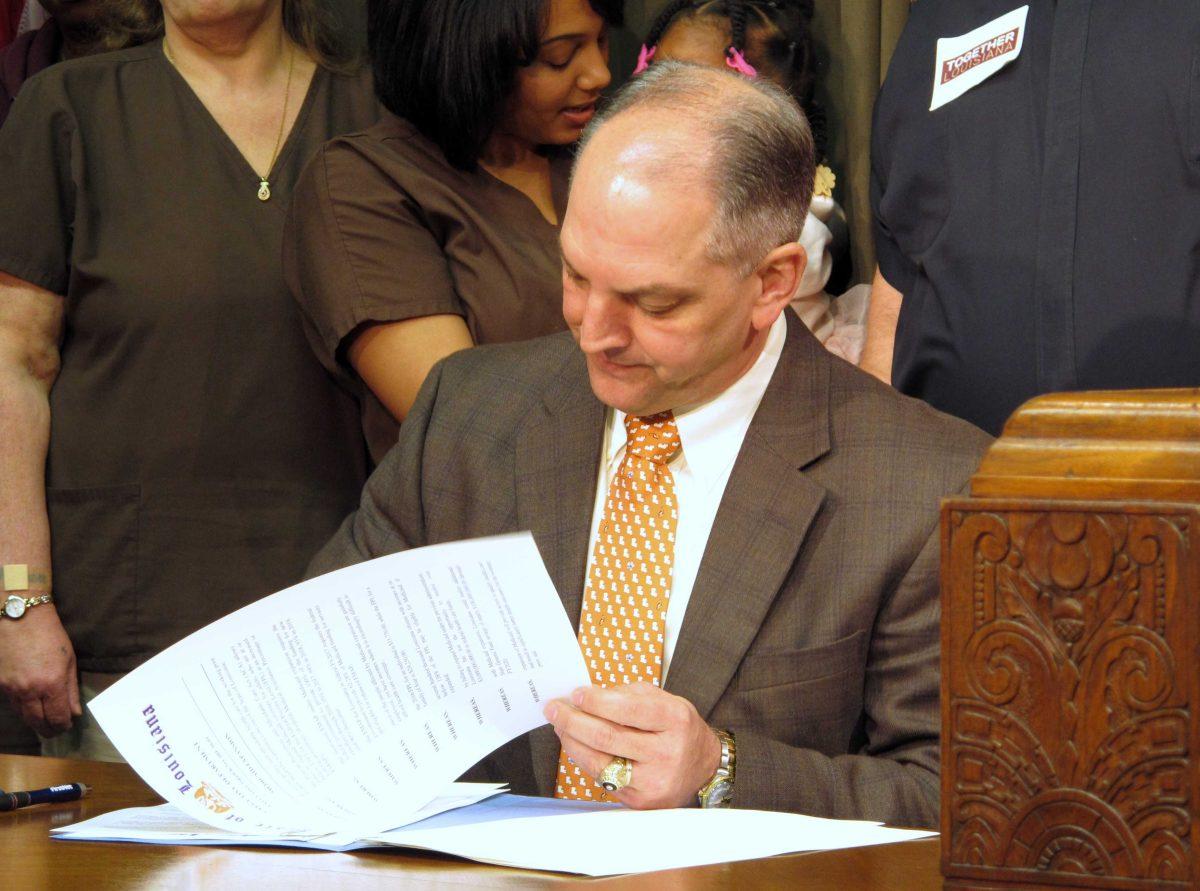 Louisiana Gov. John Bel Edwards signs an executive order on his first full day in office starting the process for expanding Louisiana's Medicaid program as allowed under the federal health care law, Tuesday, Jan. 12, 2016, in Baton Rouge, La. (AP Photo/Melinda Deslatte)