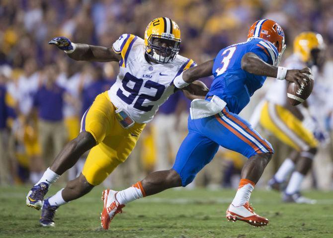 <p>LSU junior defensive end Lewis Neal (92) attempts to take down Florida sophomore quarterback Treon Harris (3) on Saturday, Oct. 17, 2015, during the Tigers' 35-28 victory against the Gators in Tiger Stadium.</p>