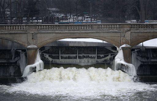 FILE - This Jan. 21, 2016 file photo shows the Flint River near downtown Flint, Mich. City leaders are floating a shockingly high price to replace the city's water infrastructure damaged after the state&#8217;s disastrous decision in 2014 to use the Flint River as the city&#8217;s drinking water source without adding a chemical to control corrosion, which caused high levels of chloride from the river to react with iron in the pipes, causing lead to leach into water for a year and a half and contributing to a spike in child lead poisoning before city and state officials fully acknowledged the problem. (AP Photo/Paul Sancya, File)