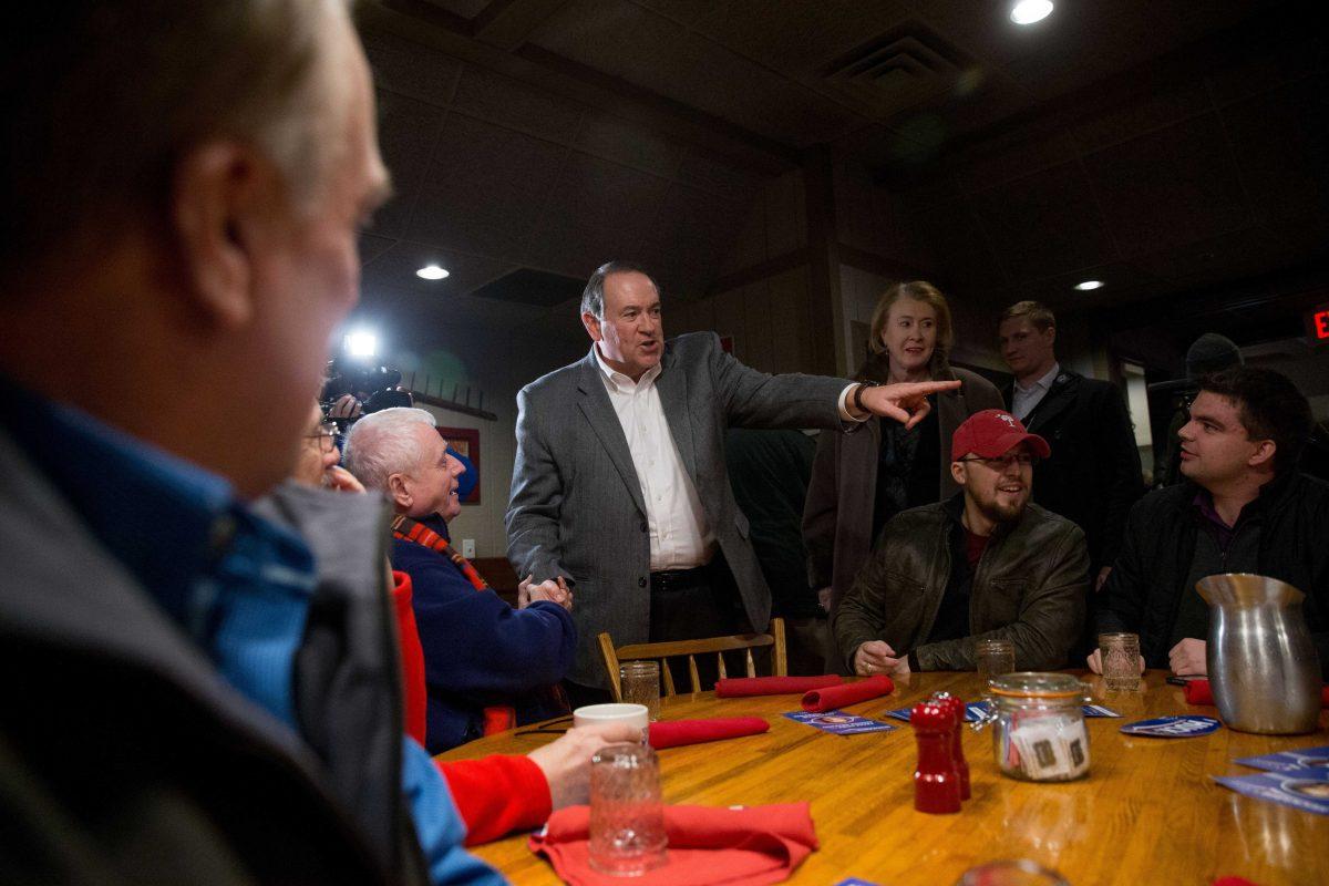 Republican presidential candidate former Arkansas Gov. Mike Huckabee, accompanied by his wife Janet, center right, greets guests before he speaks at the Machine Shed in Urbandale, Iowa, Sunday, Jan. 3, 2016. (AP Photo/Andrew Harnik)