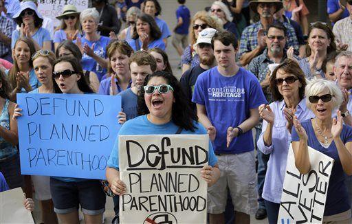 FILE- In this July 28, 2015 file photo, Erica Canaut, center, cheers as she and other anti-abortion activists rally on the steps of the Texas Capitol in Austin, Texas to condemn the use in medical research of tissue samples obtained from aborted fetuses. Two state health researchers in Texas are under fire for a co-authoring a study suggesting what Republican leaders have long disputed - that cuts to Planned Parenthood are hurting access to women&#8217;s health care. (AP Photo/Eric Gay, File)