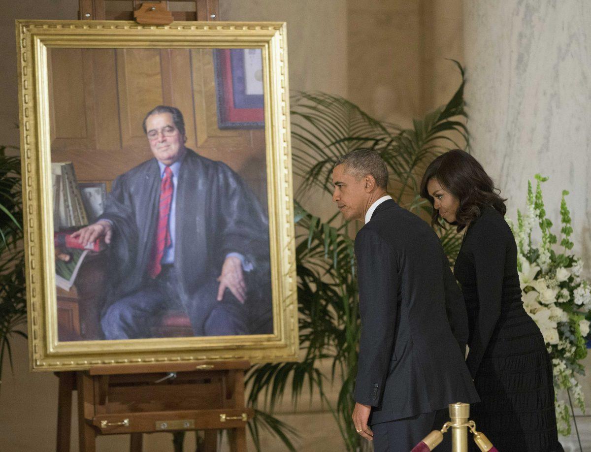 President Barack Obama and first lady Michelle Obama stops at a portrait of Supreme Court Justice Antonin Scalia after paying their respects at Scalia's casket in the Great Hall of the Supreme Court in Washington, Friday, Feb. 19, 2016. (AP Photo/Pablo Martinez Monsivais)