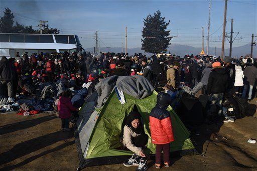 A woman leave her tent, as migrants and refugees wait allowance to continue their trip to southern Macedonia, near the northern Greek village of Idomeni, on Wednesday, Feb. 3, 2016. Police in northern Greece late Tuesday said 5,000 refugees and migrants were gathered at or near the border with Macedonia, where authorities continued to provide limited access at a frontier barrier built in November.(AP Photo/Giannis Papanikos)